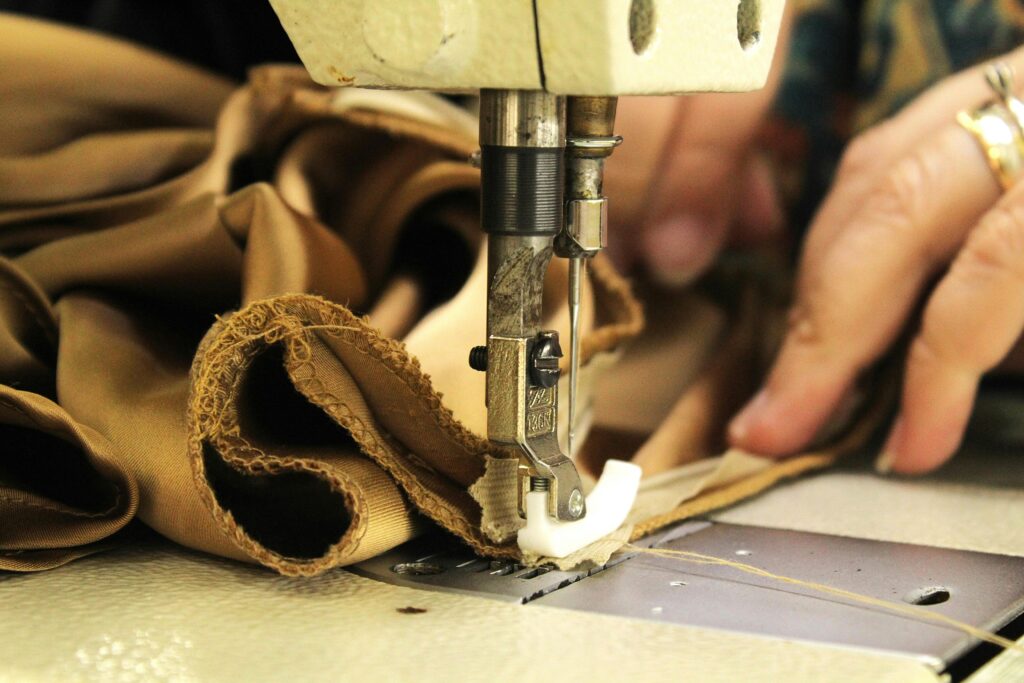Focused view on sewing machine stitching fabric, highlighting craftsmanship.